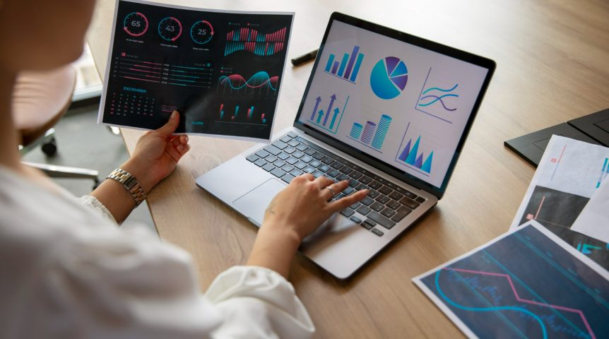 jornada-do-cliente Imagem ilustrando o conteúdo sobre jornada do cliente mostrando dois profissionais usando IA e análise de dados para otimizar essa jornada. Eles analisam diversos gráficos e dados fornecidos pela IA para isso.