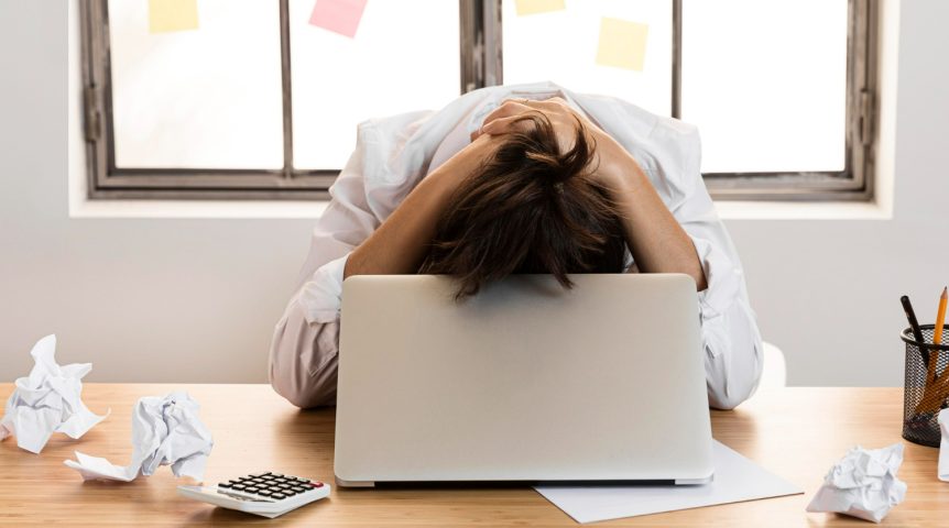 Imagem ilustrando o conteúdo sobre como evitar a procrastinação, mostrando uma mulher frustrada trabalhando em home office.