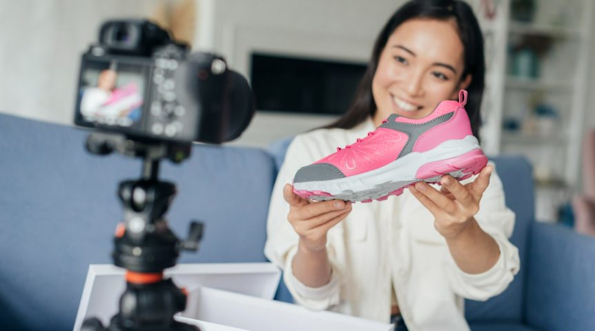 live-commerce Imagem ilustrando o conteúdo sobre live commerce mostrando uma vendedora ofertando tênis em live.