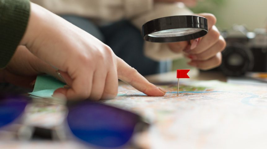 seo-local Imagem ilustrativa sobre SEO local mostrando pessoas buscando um ponto específico no mapa com uma lupa.