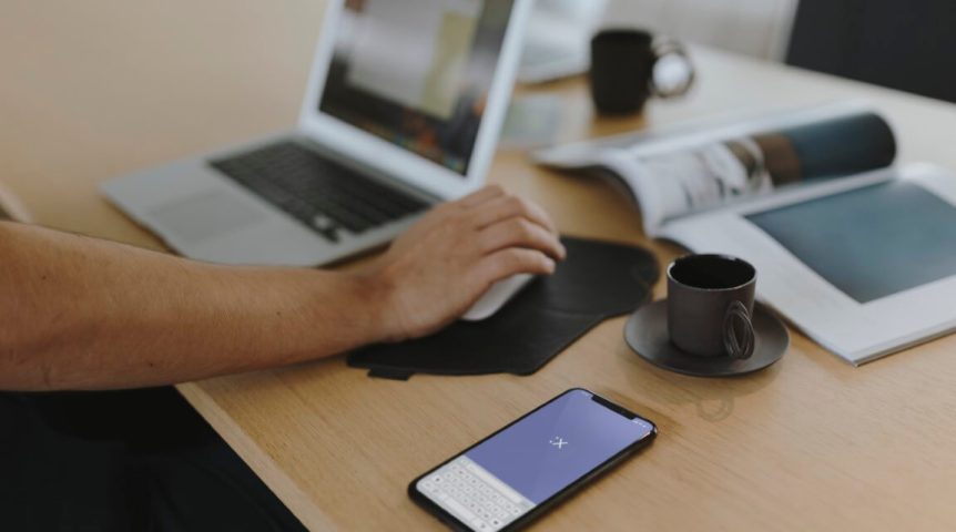 Como criar um site médico e conquistar novos pacientes Web designer trabalhando na criação de um site médico, testando no notebook e celular.