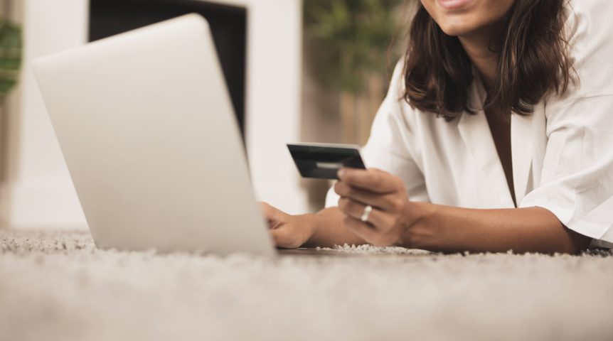 vendas-online Mulher investindo em vendas online, sorrindo em frente ao computador.