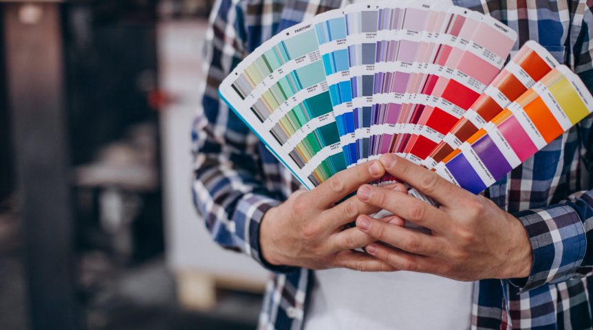 Homem segurando papéis com paletas de cores, para representar a psicologia das cores no marketing