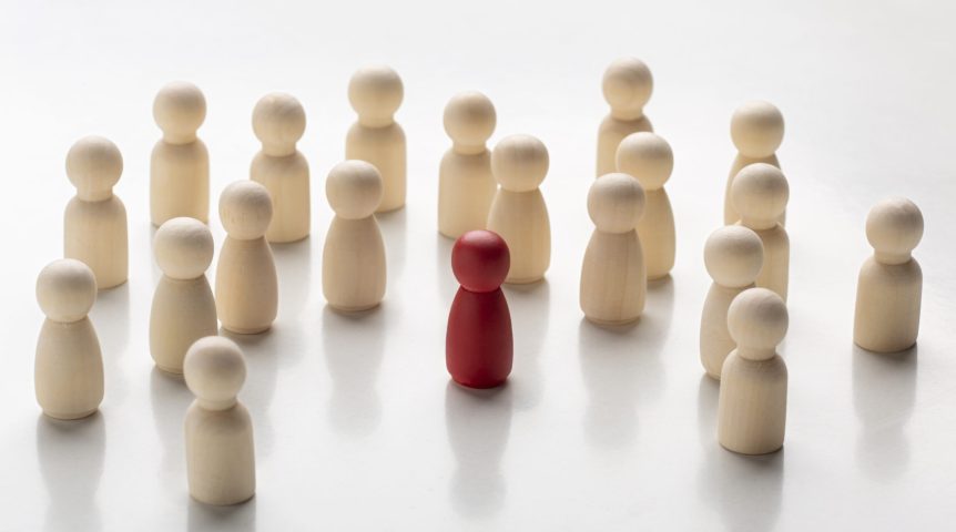 Pinos de madeira natural e um pino vermelho representando leads qualificados