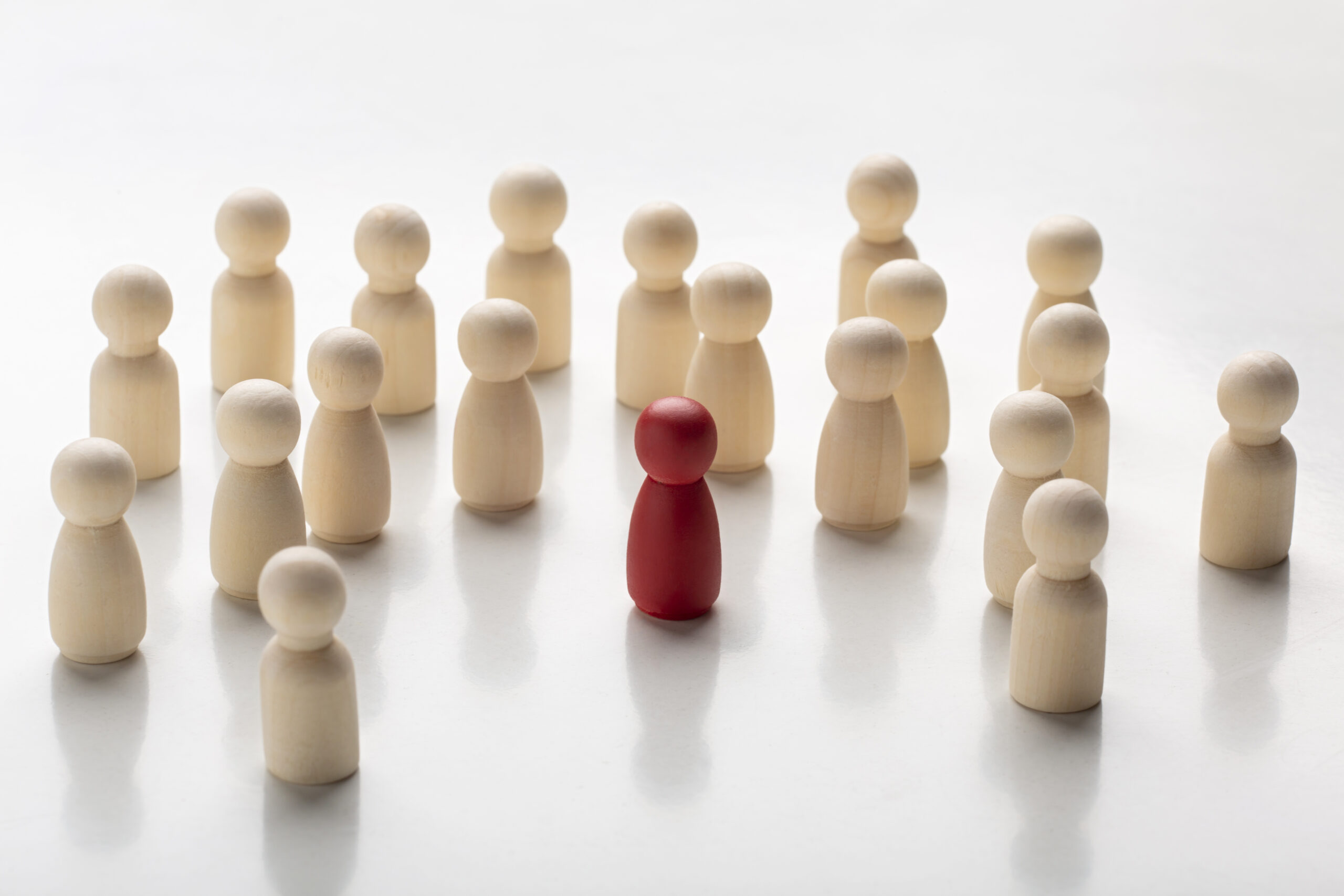 Pinos de madeira natural e um pino vermelho representando leads qualificados