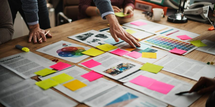 Imagem ilustrativa sobre o que é infoproduto mostrando uma equipe de marketing desenvolvendo a escada de valor para seu cliente.