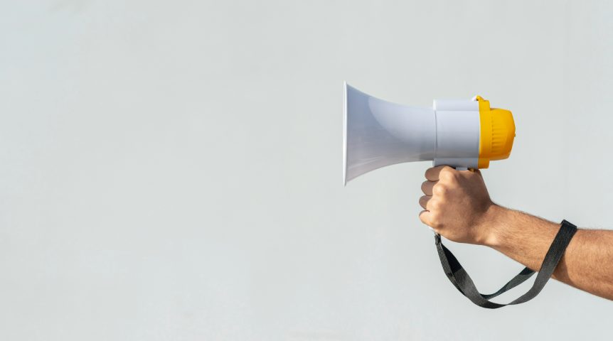 Imagem ilustrando o conteúdo sobre gestão de tráfego mostrando um profissional de marketing segurando um megafone para ilustrar o alcance de suas campanhas.