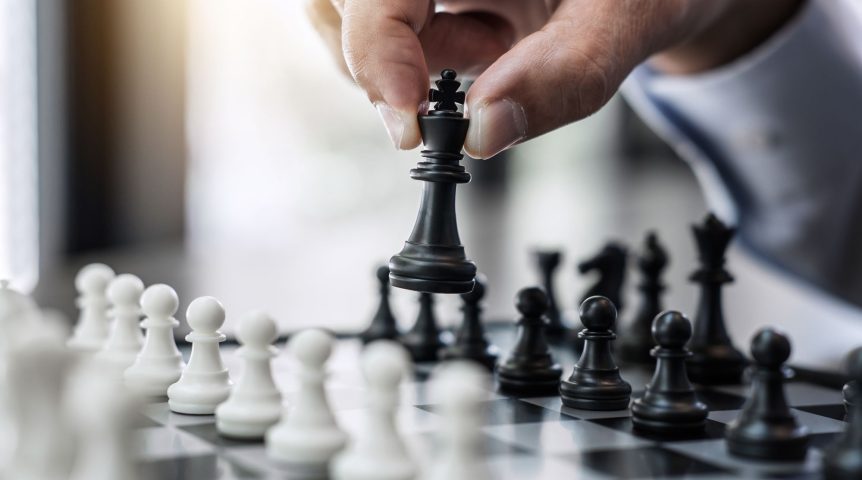 Businessman's hand playing chess game to development analysis new strategy plan, business strategy leader and teamwork concept for win and success.