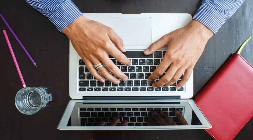 Imagem mostrando as mãos de um jovem empresário, que está construindo a presença digital de sua empresa.