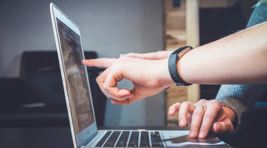 web designer apontando para o computador, desenvolvendo um site que representa sua marca