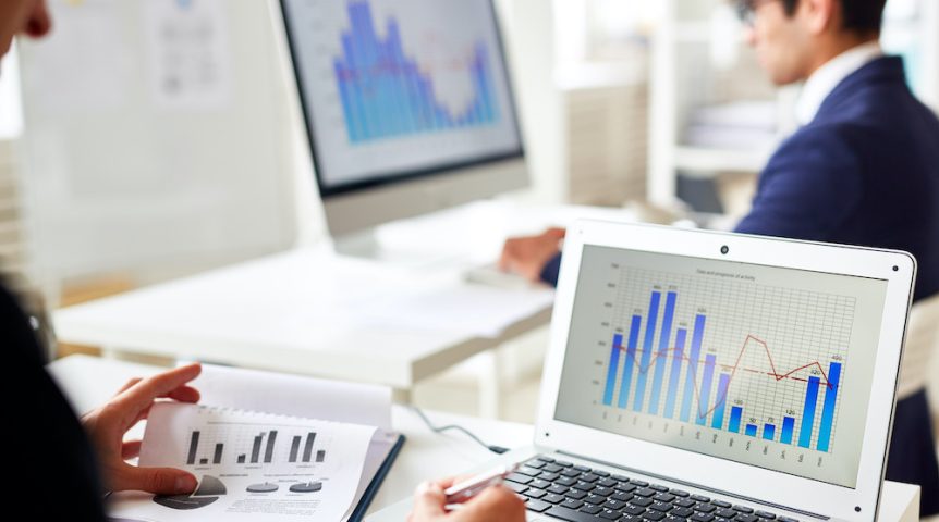 computadores exibindo dados e gráficos de um programa de gestão financeira
