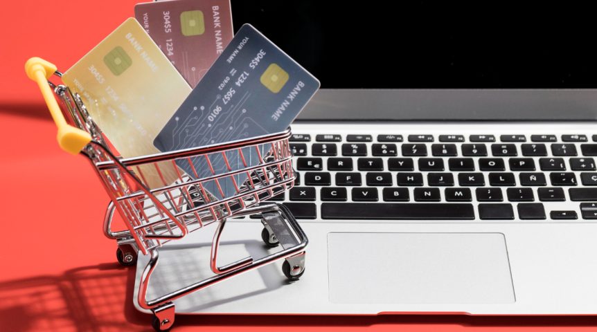 Imagem ilustrativa sobre criação de e-commerces em Curitiba, mostrando um carrinho de compras, cartões de crédito e um notebook.
