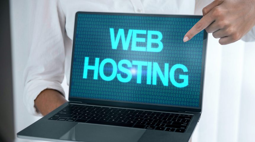 Pessoa apontando para a tela do notebook, onde está escrito "web hosting", exemplificando uma hospedagem de sites.