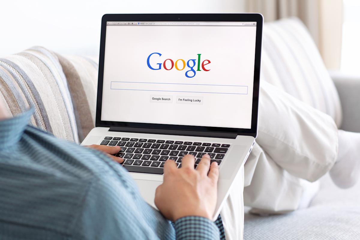 Pessoa com um notebook no colo, mostrando a página inicial do Google, para representar as core web vitals.