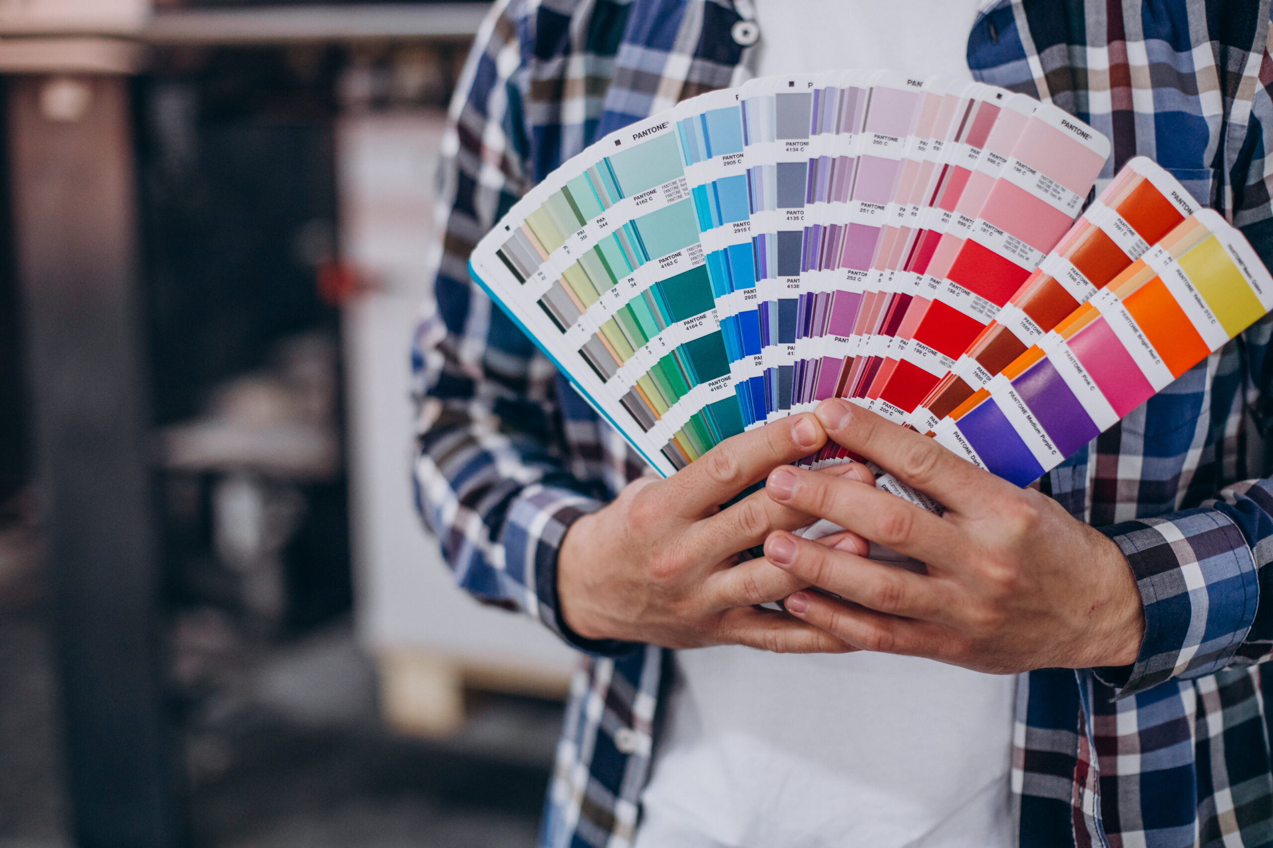 Homem segurando papéis com paletas de cores, para representar a psicologia das cores no marketing